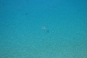 Relaxing swimmer floating in blue water ripples